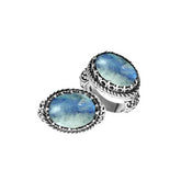 Handcrafted Bali sterling silver ring with oval Rainbow Moonstone, Blue Quartz, and ornate scroll design for retail customers.